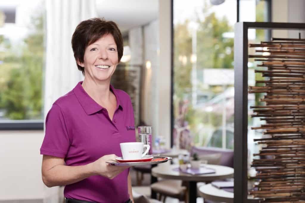 Servicedame mit Kaffeetasse in der Hand